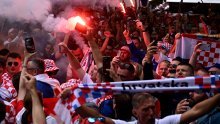 Hrvatski navijači u korteu s najvećom zastavom na stadionu; skandira se Modriću