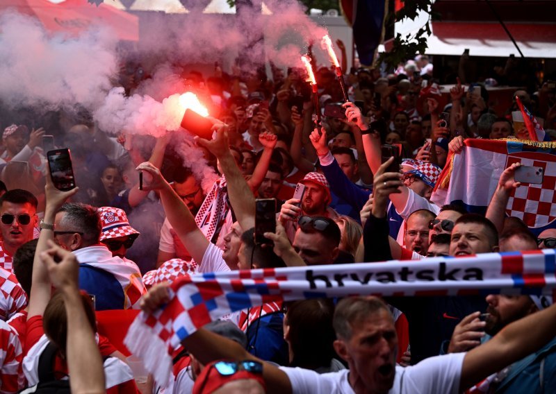Hrvatski navijači u korteu s najvećom zastavom na stadionu; skandira se Modriću