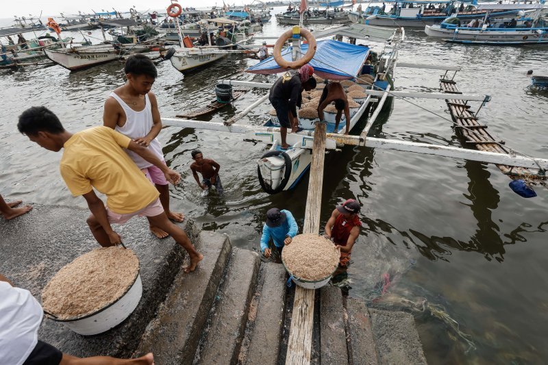 Ribari dovoze čamce na obalu i istovaruju svoj ulov u obalnom selu u Navotas Cityju, Metro Manila, Filipini. Obalna sela pokušavaju izloviti što je moguće više ribe dok su vode još mirne, dok filipinski meteorološki ured prati kretanje tajfuna Mawar.