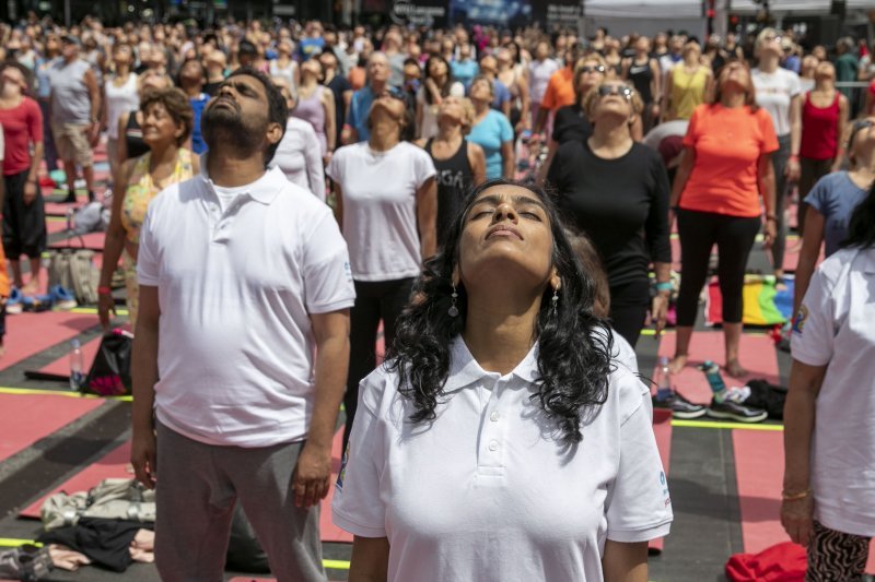 Ljudi sudjeluju u satu joge održanom na Times Squareu u New Yorku na ljetni solsticij, 21. lipnja.