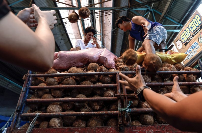 Radnici istovaraju kamion kokosa na tržnici u filipinskoj Manili.