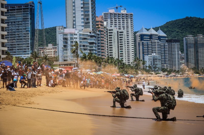 Pripadnici meksičke mornarice sudjeluju u vježbi spašavanja dok turisti gledaju na plaži 'Icacos' u ljetovalištu Acapulco.