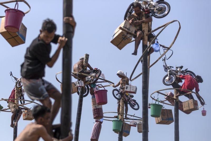 Sudionici se penju po podmazanim stupovima na plaži Ancol u Jakarti tijekom utrke lokalno poznate kao 'Panjat Pinang' kojom se obilježava 78. godišnjica dana neovisnosti Indonezije.