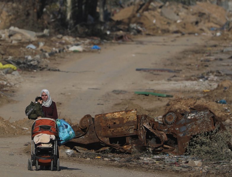 Palestinka s djetetom hoda duž ceste Salah Al Din nakon prelaska iz sjevernog u južni dio Pojasa Gaze.