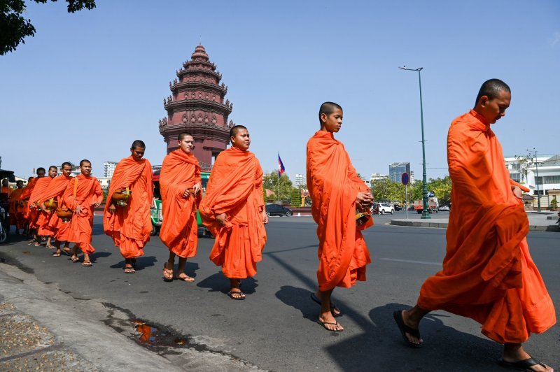 Budistički redovnici hodaju ulicom u blizini spomenika nezavisnosti u Phnom Penhu u Kambodži.