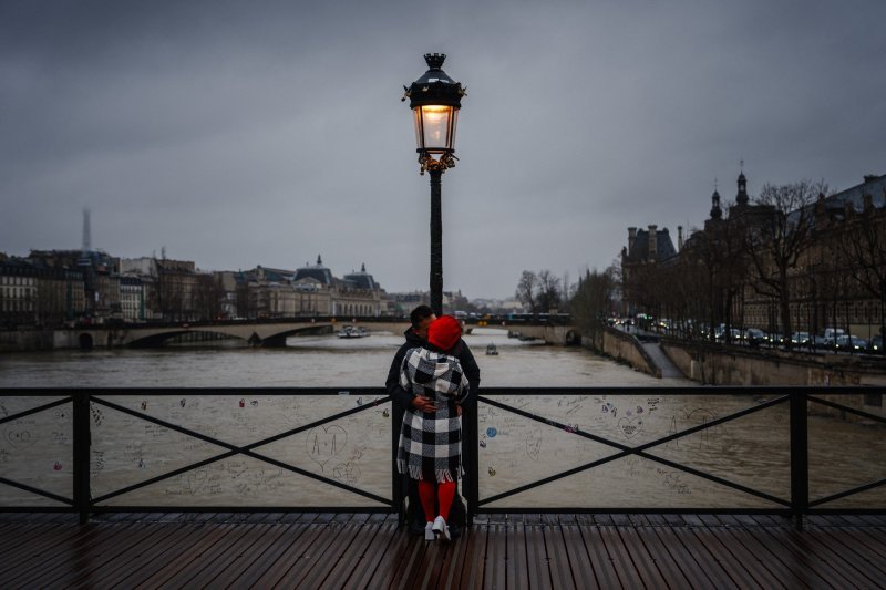 Par se ljubi na mostu Pont des Arts preko rijeke Seine u središtu Pariza.