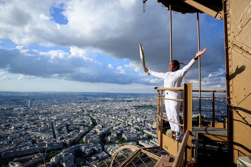 Francuska judašica Clarisse Agbegnenou drži olimpijsku baklju na Eiffelovom tornju kao dio štafete Olimpijske baklje u Parizu, uoči Olimpijskih igara u Parizu 2024.