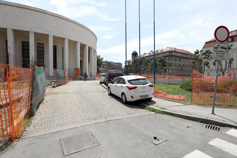 Automobili izvođača i radnika parkirani unutar ograde gradilišta na Trgu žrtava fašizma