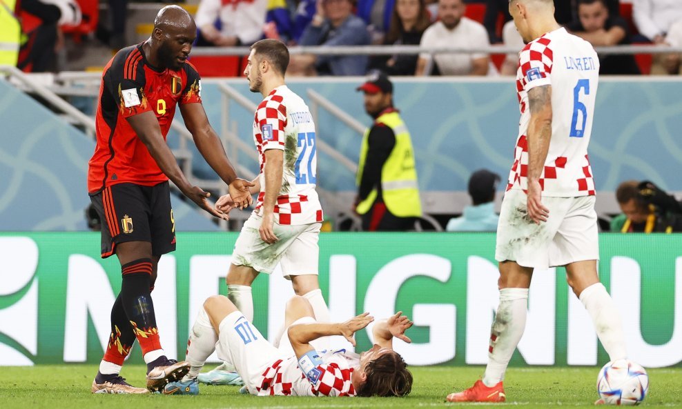 Romelu Lukaku pruža ruke Luki Modriću kako bi mu pomogao ustati