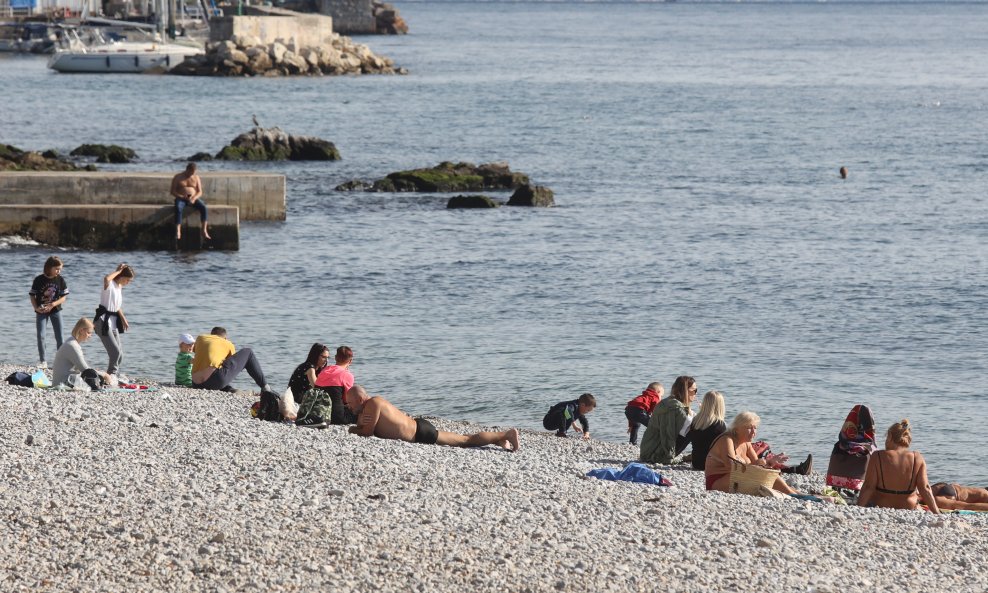 Ljudi uzivaju u toplom i suncanom danu na plazi Kantrida