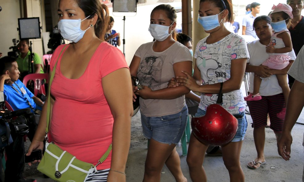 Relatives arrive at a municipal hall to identify bodies of loved ones who were killed in a factory fire in Valenzuela city, north of Manila, May 14, 2015. The death toll has risen to 72 in a fire that gutted a rubber slipper factory in the Philippine capi